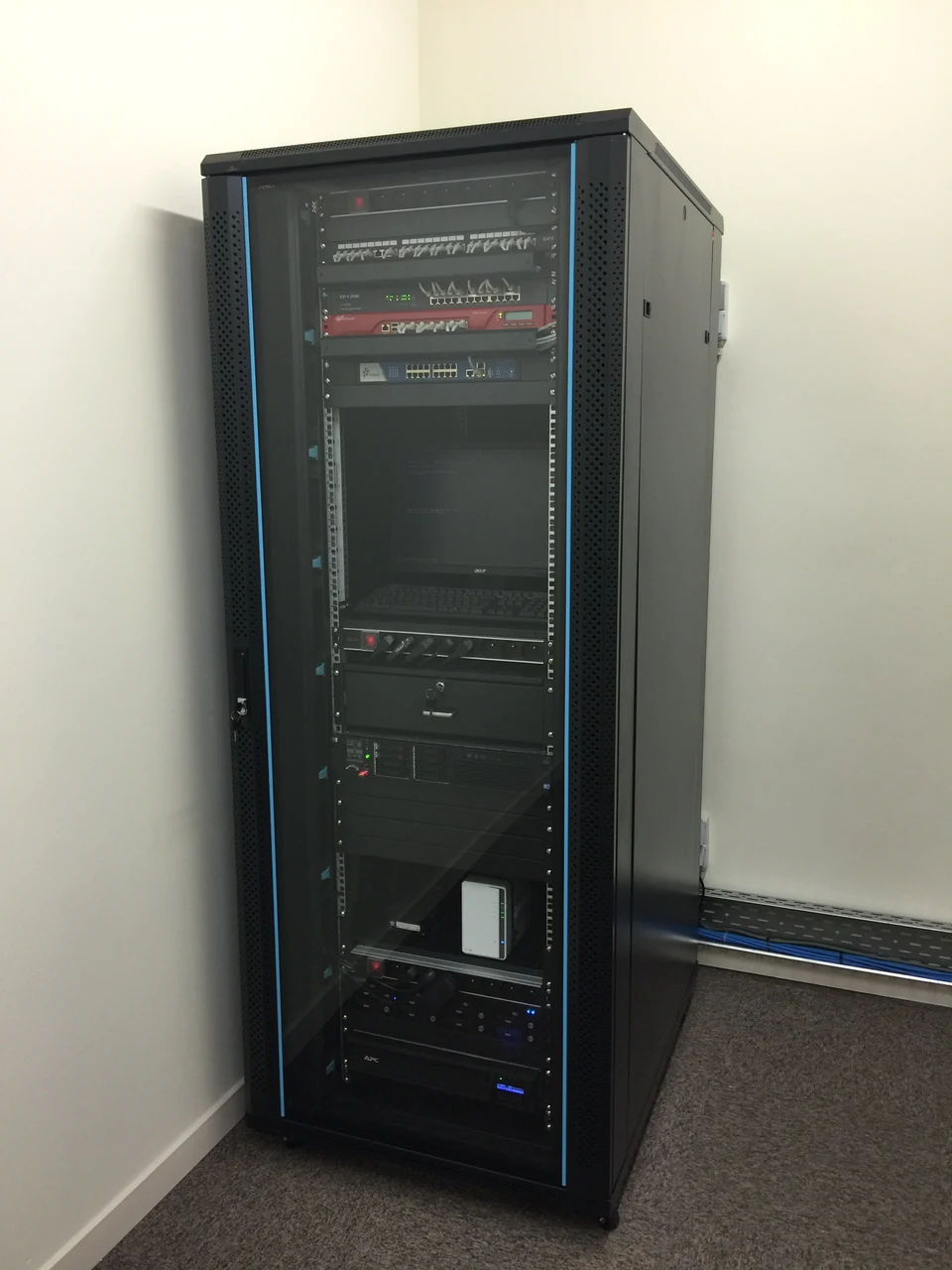 Installed network rack with organised patch cables, switch and firewall